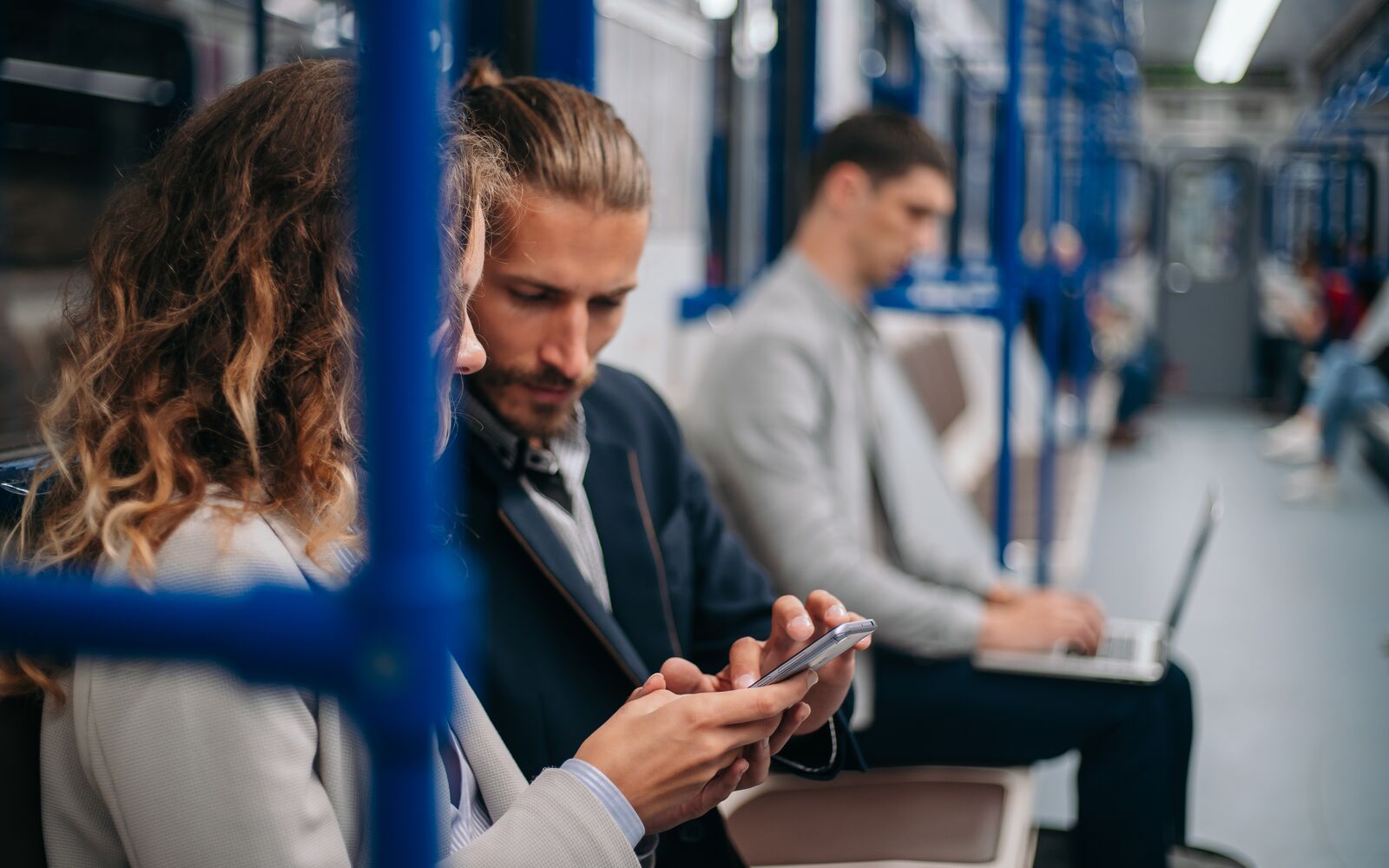 young couple discussing online news in a subway car .